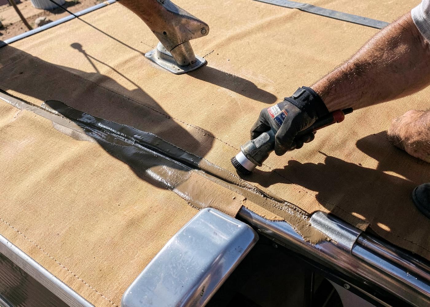 Technician applying fresh sealant along an RV roof seam